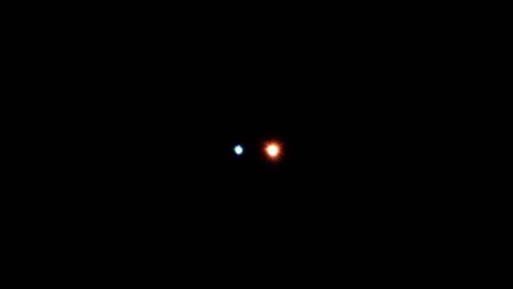 Albireo, estrella doble de un punto azul y otro anaranjado